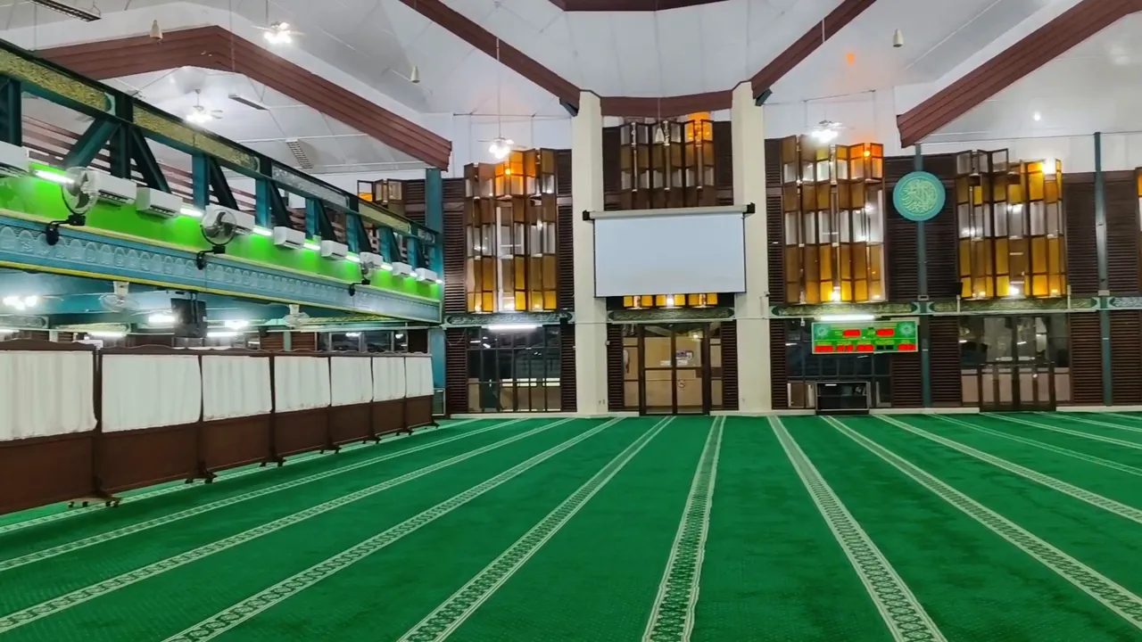 Ruang sholat utama dengan karpet hijau.